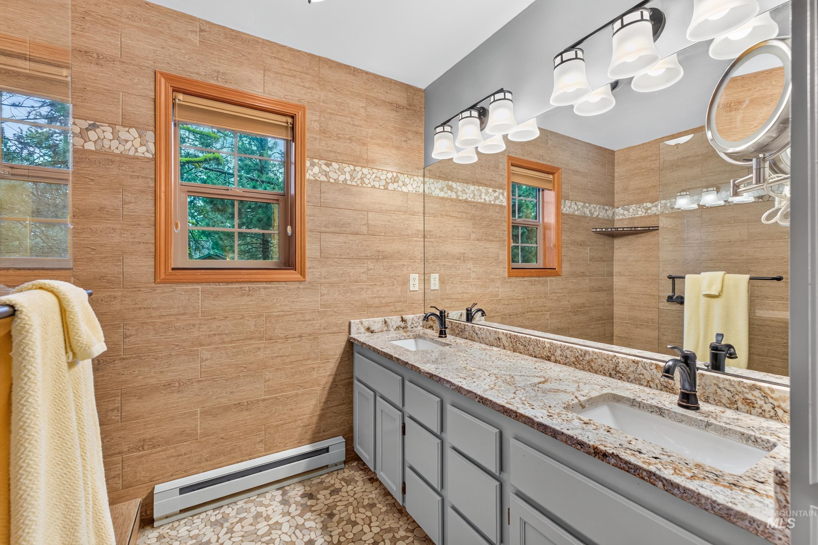 Dual vanity with light gray cabinetry, granite countertops, and two rectangular undermount sinks