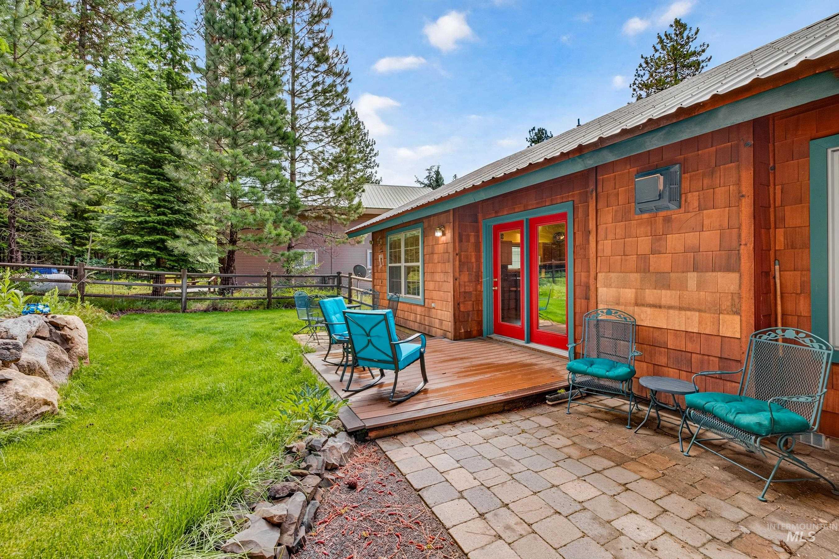 Outdoor living space featuring a wood deck and an interlocking paver patio