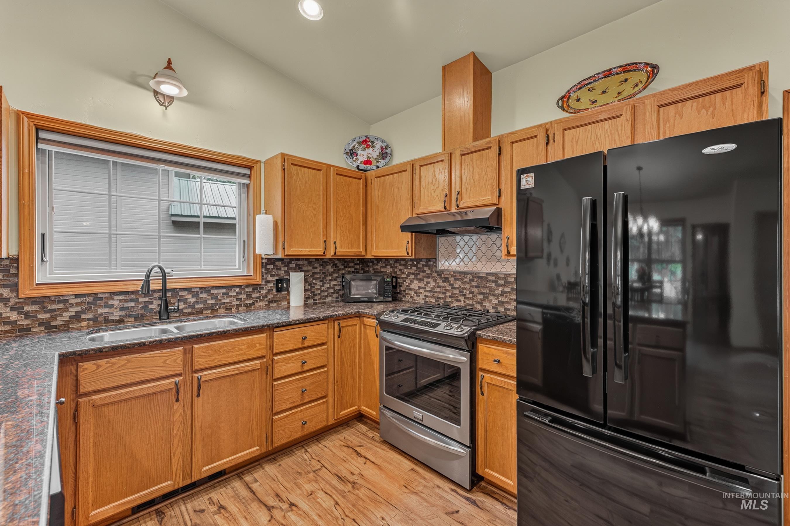Kitchen featuring wood-finish flooring and oak cabinetry
