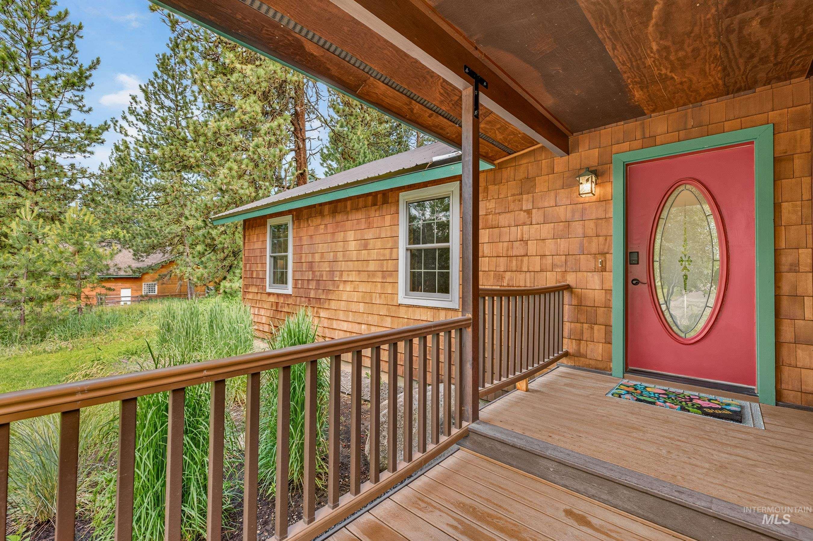 Covered front porch featuring wood-finish decking and railing