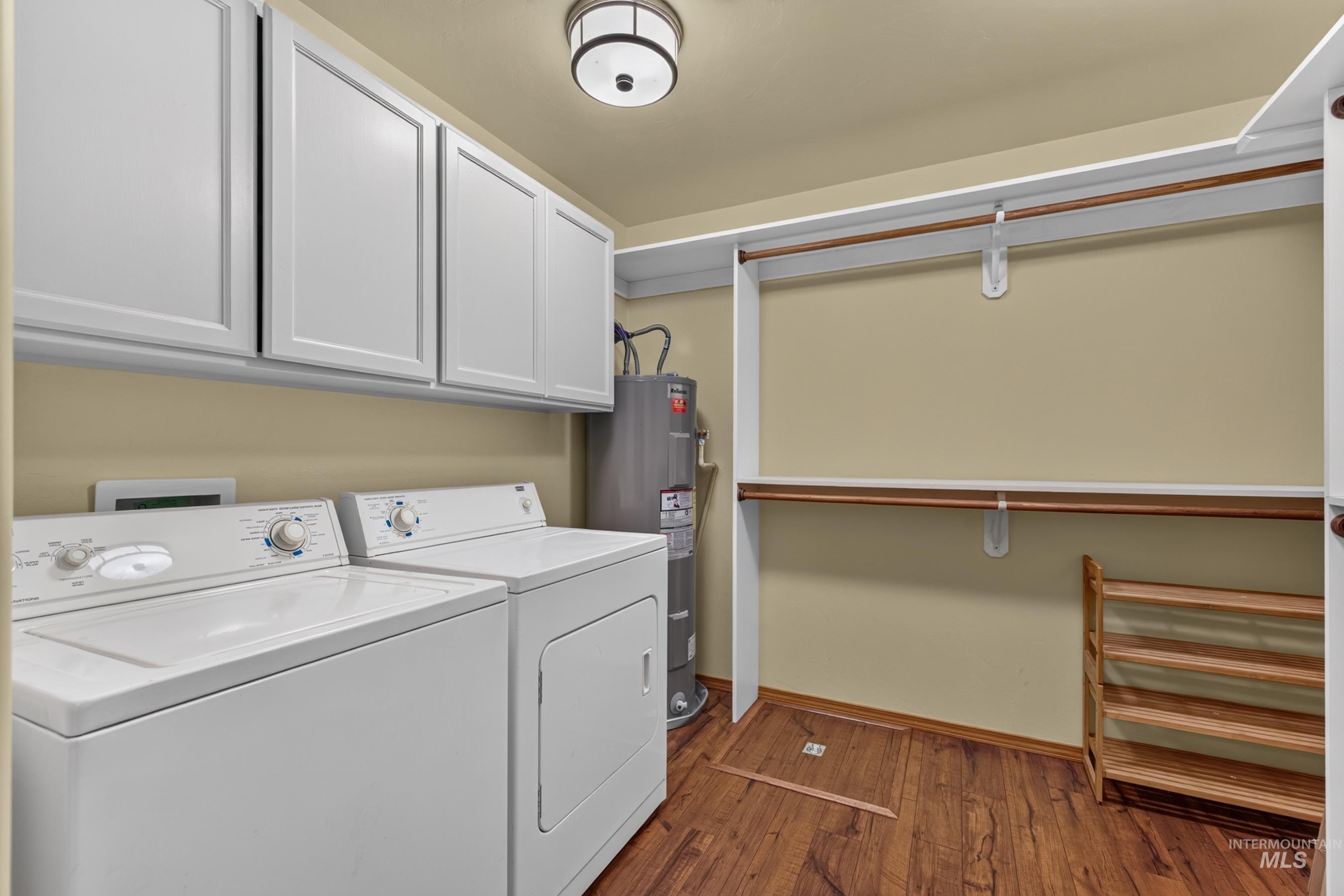Laundry area featuring a ceiling-mounted light fixture, white upper cabinetry, wood-finish flooring, and built-in shelving