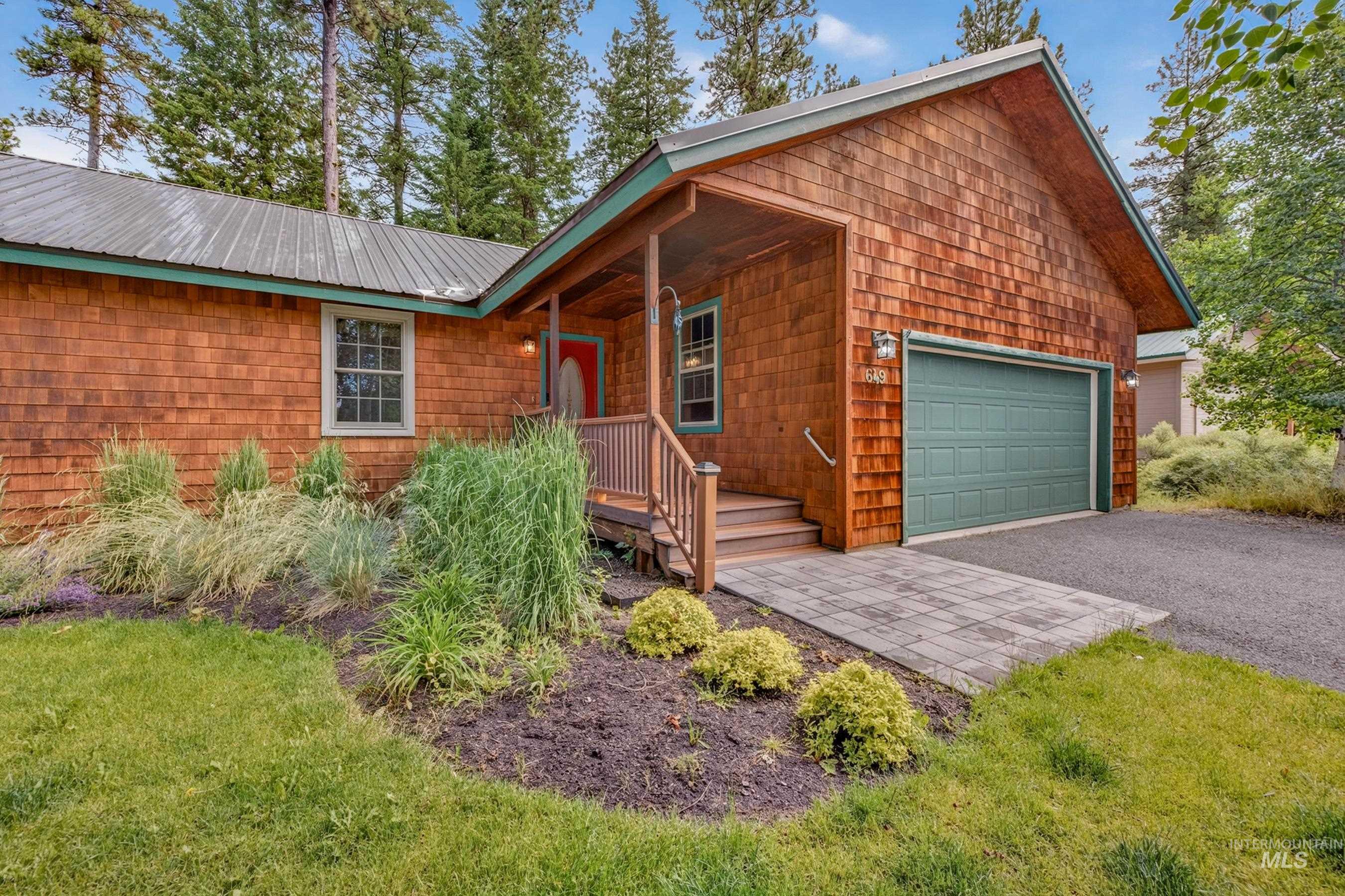 Cedar shake siding exterior with a metal roof and a covered porch entry