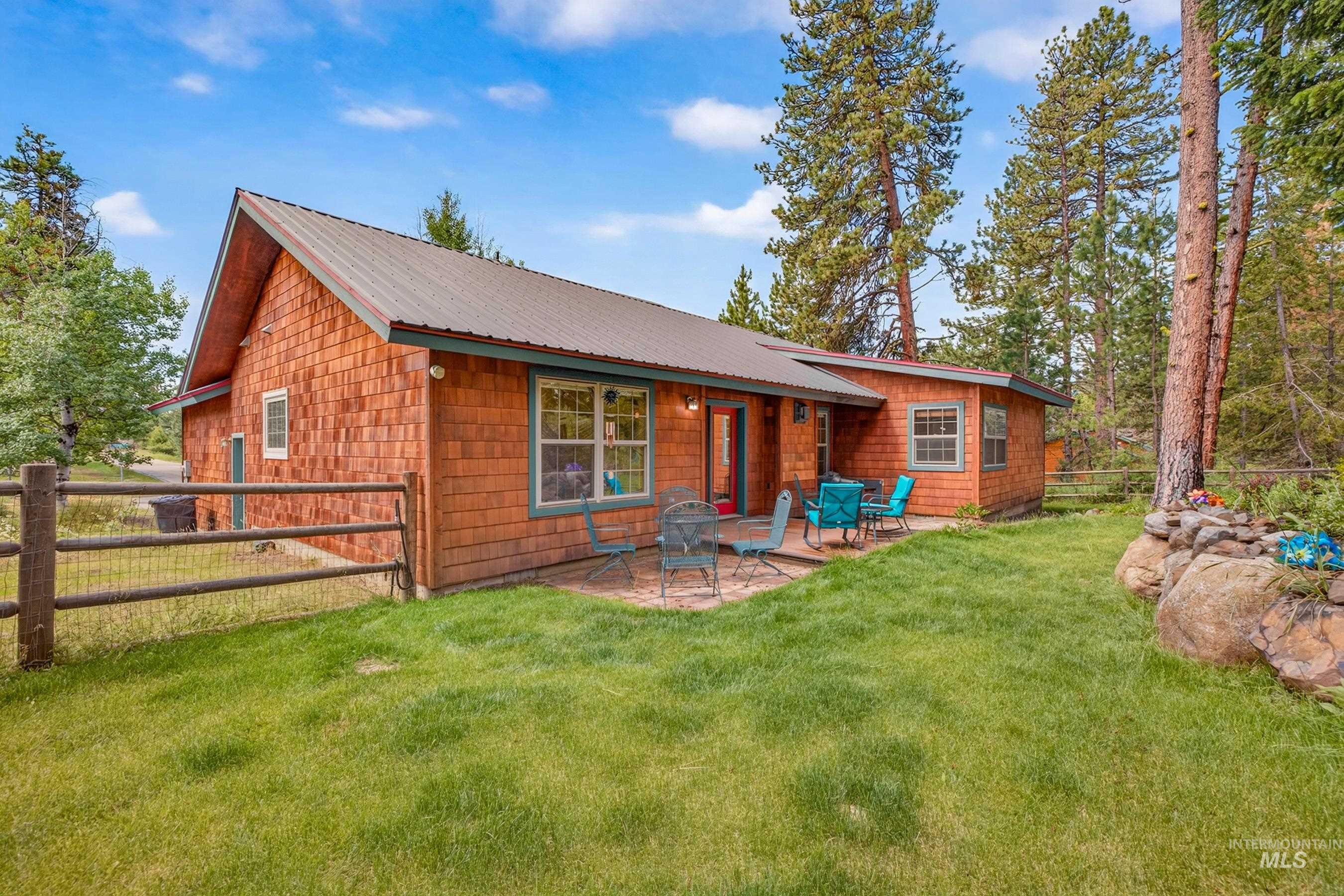 Wood-shingle exterior with a metal roof and a stone patio