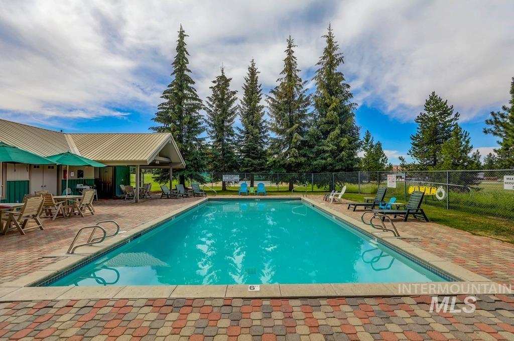Outdoor swimming pool with integrated steps, surrounded by multi-toned paver decking