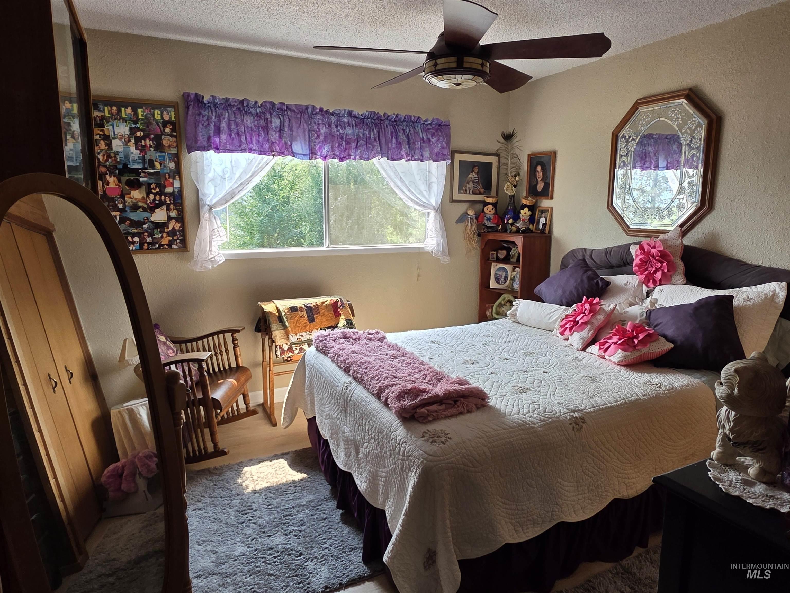 Bedroom featuring a textured ceiling, ceiling fan, and wood finished floors