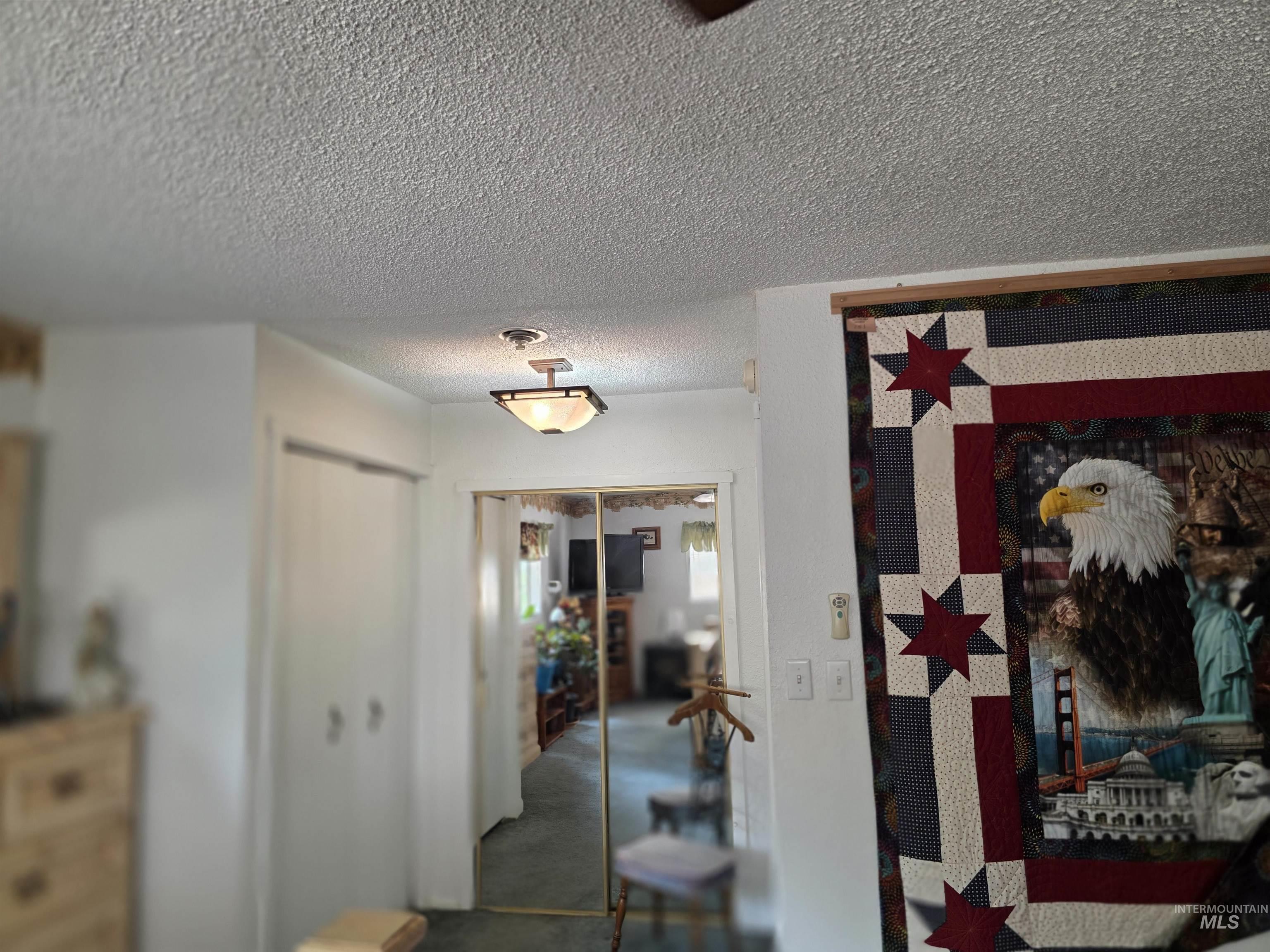 Corridor featuring a textured ceiling