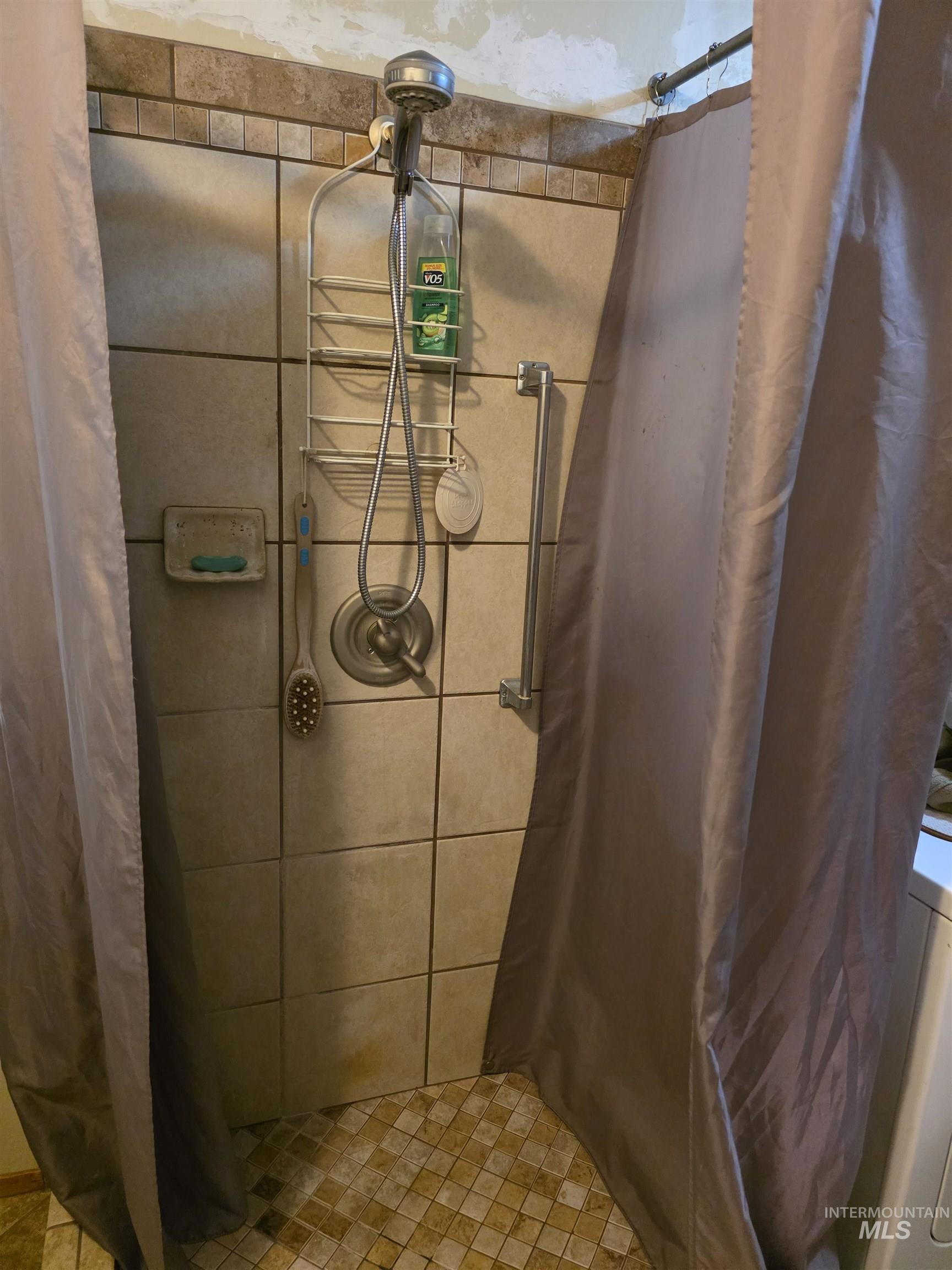 Bathroom featuring a stall shower and washer / clothes dryer