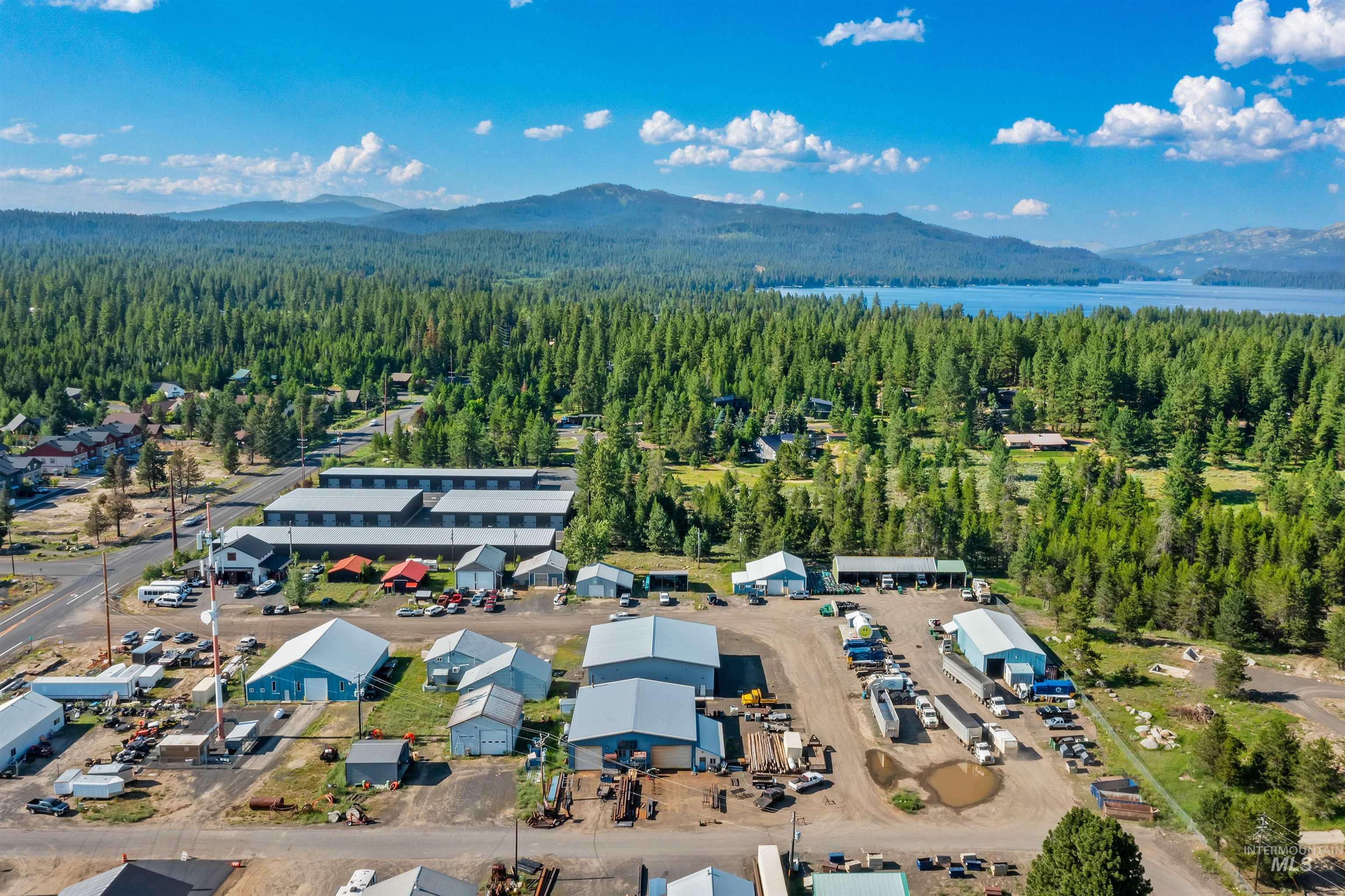 Aerial overview of property's location featuring a mountainous background and a forest