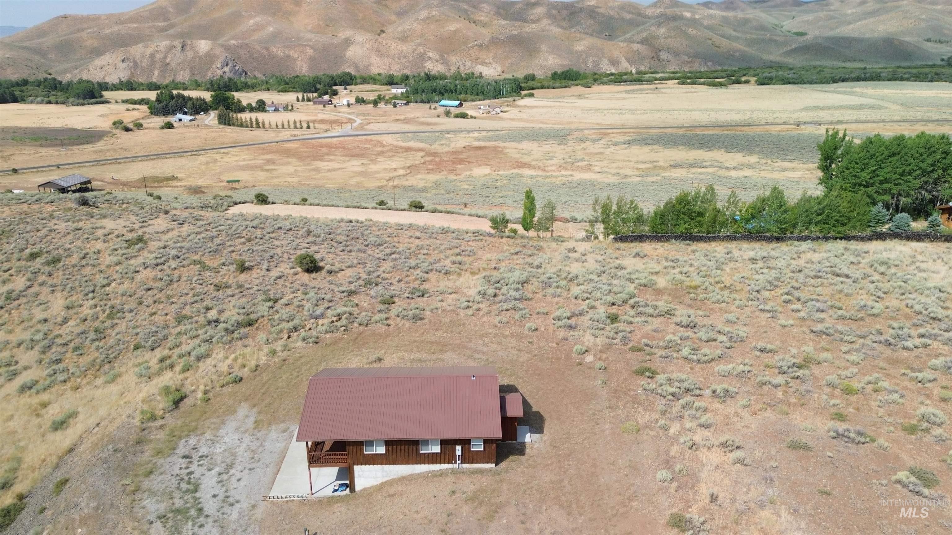 Aerial overview of property's location featuring rural landscape and mountains