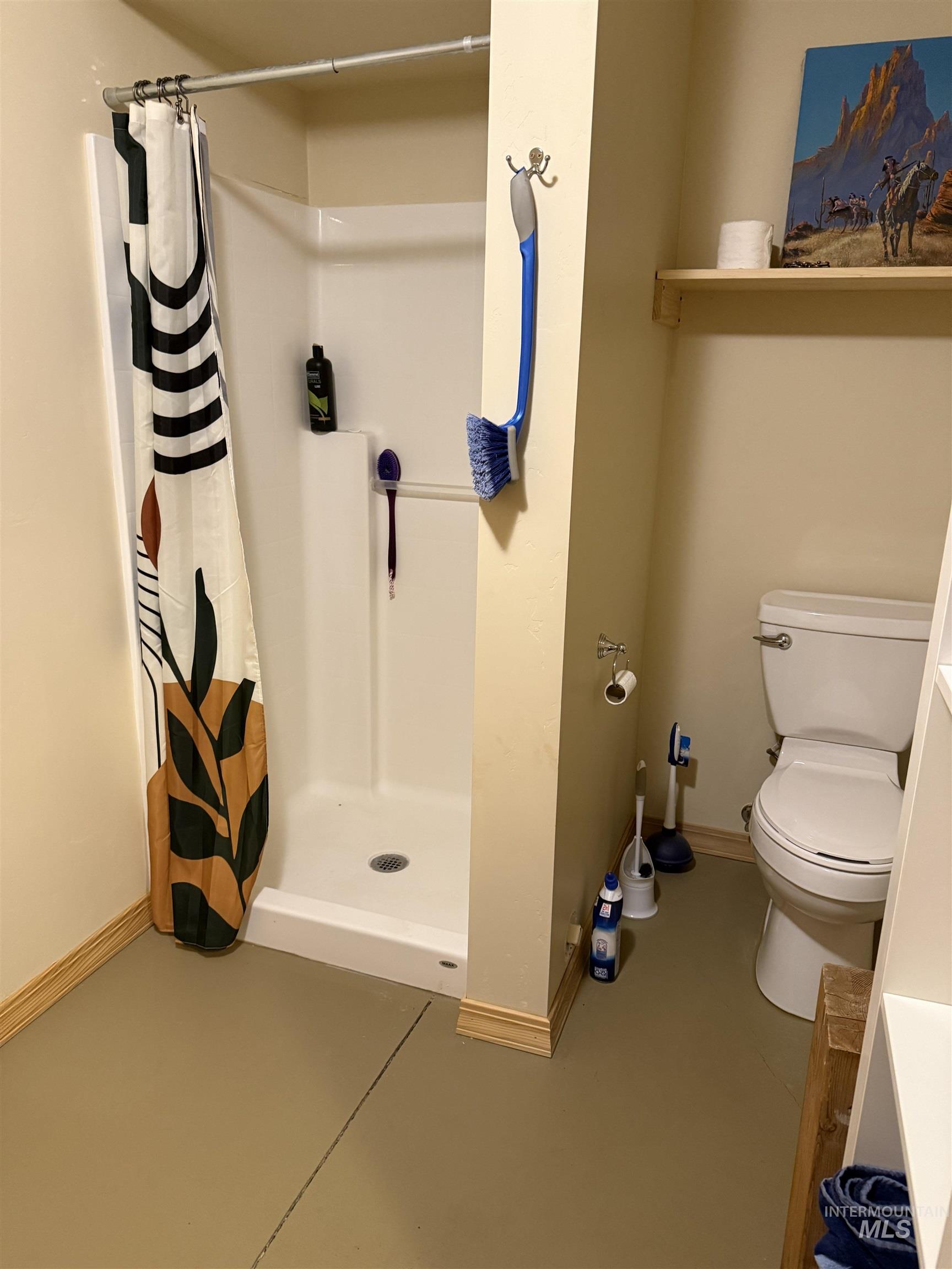 Downstairs bathroom with a stall shower and concrete floors