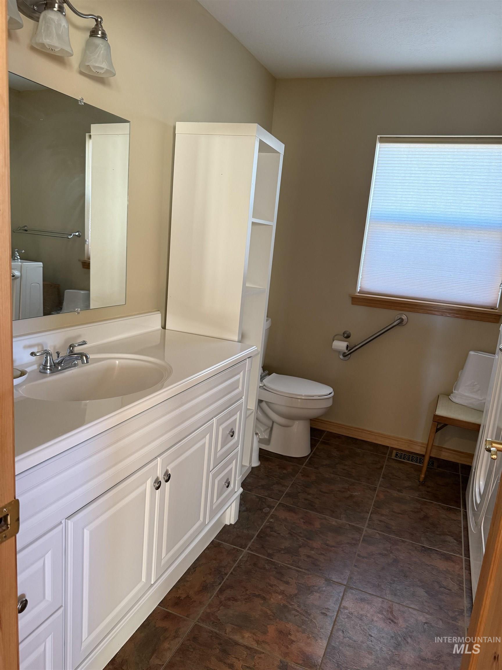 Half bathroom with vanity and dark tile patterned floors