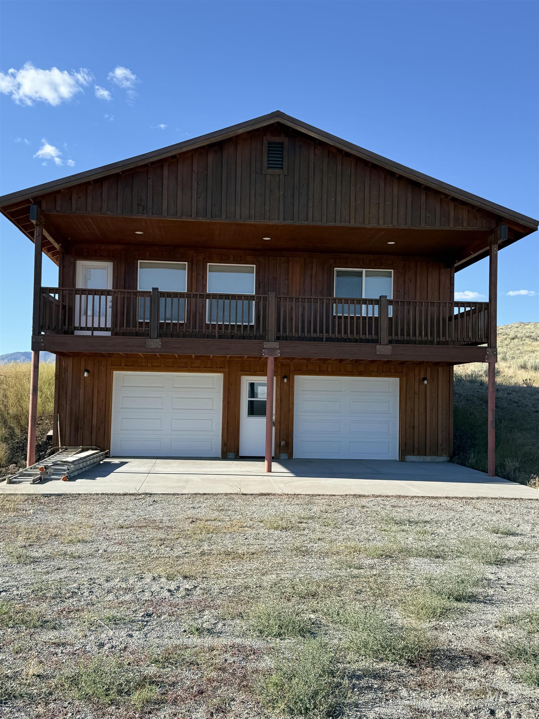 View of front facade with an attached garage and gravel driveway