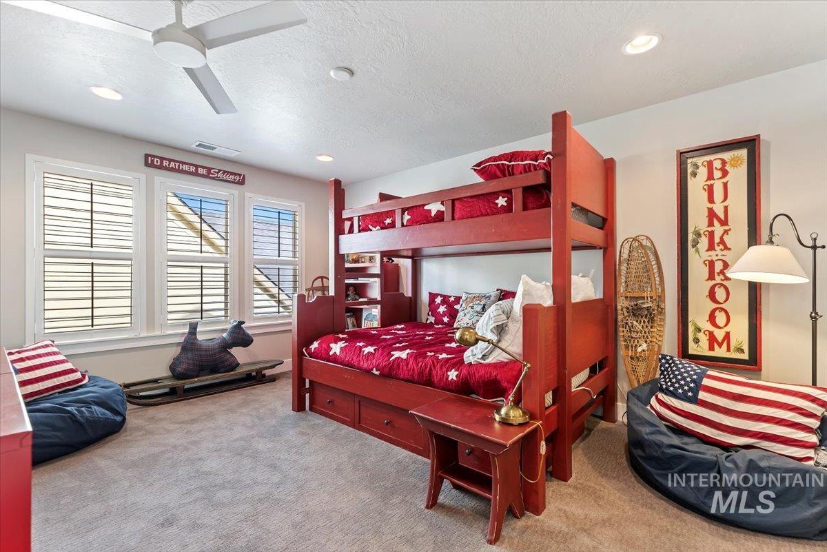 Carpeted bedroom with a textured ceiling, a ceiling fan, and recessed lighting