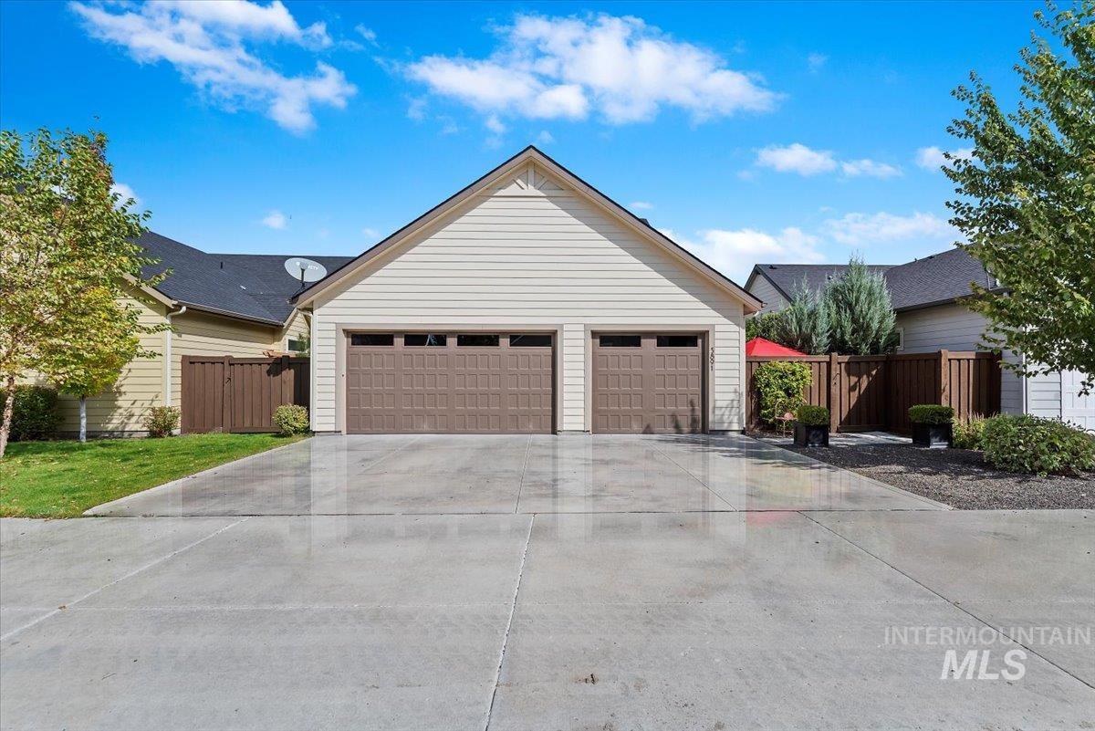 Single story home featuring a garage, an outdoor structure, and concrete driveway