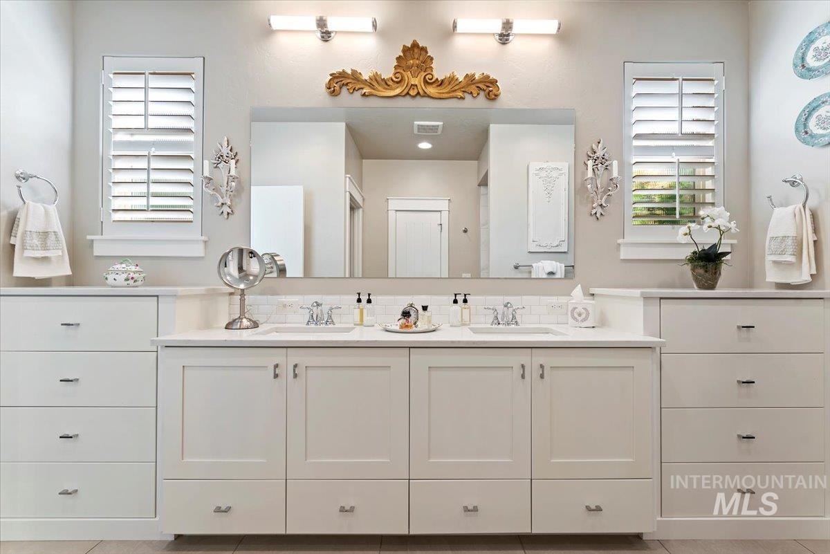 Full bath with double vanity and light tile patterned flooring