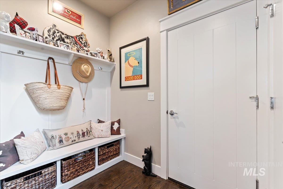 Mudroom featuring dark wood-style floors and baseboards