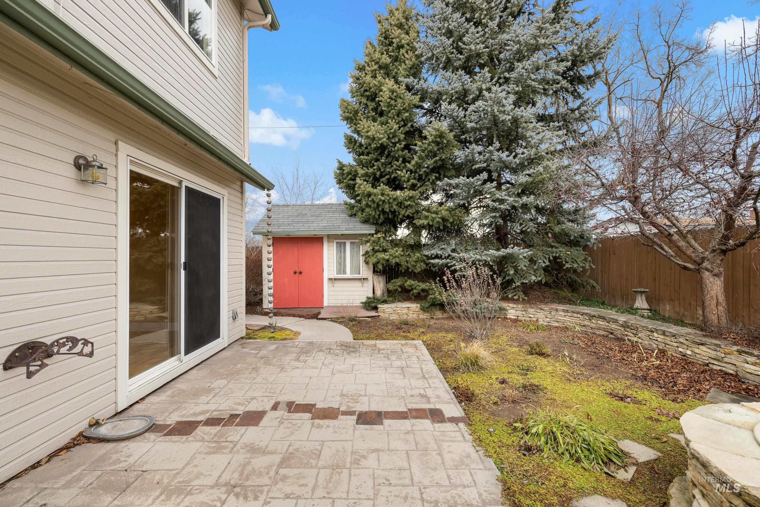 Fenced backyard with a patio area and a storage unit
