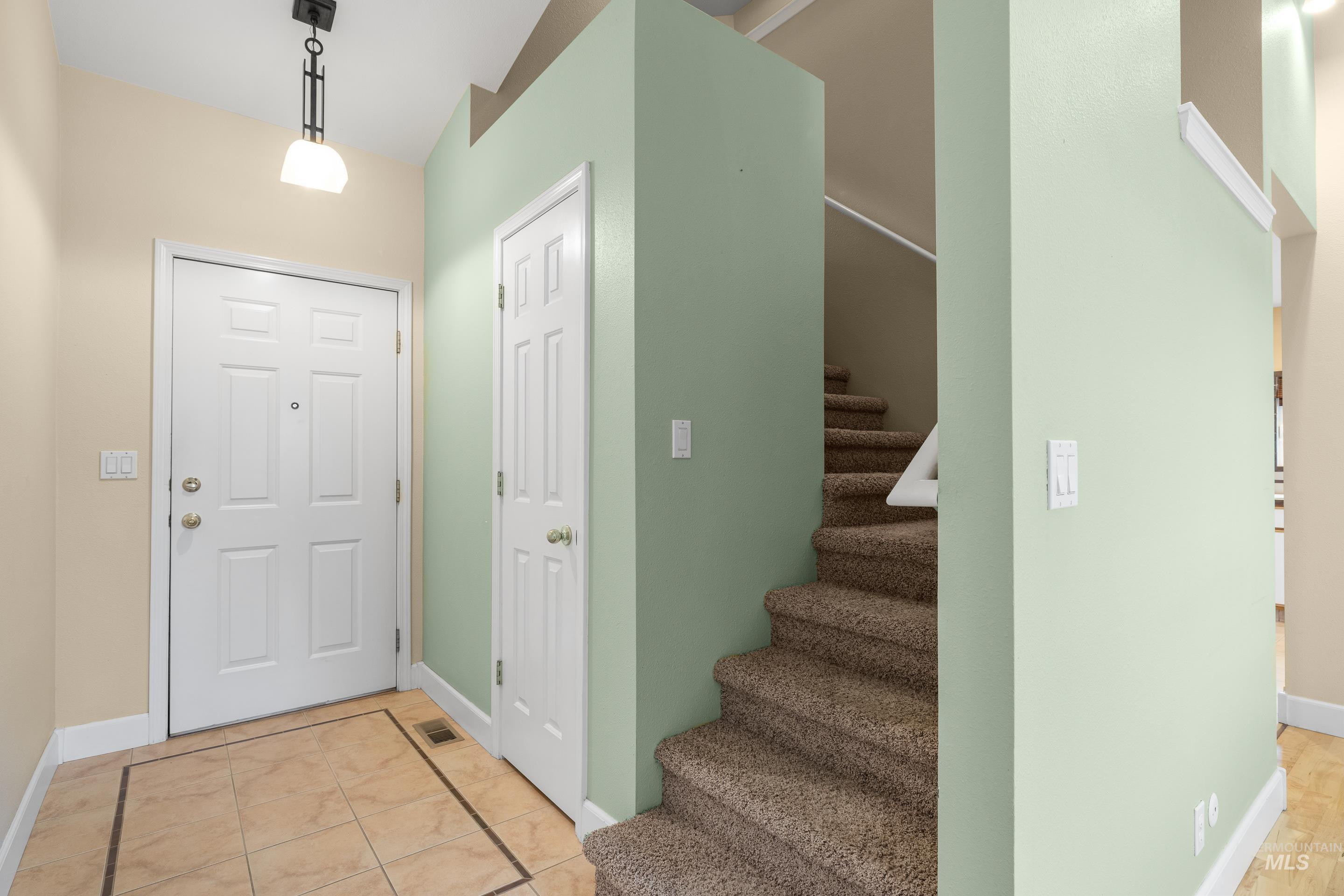 Entrance foyer with stairs and baseboards