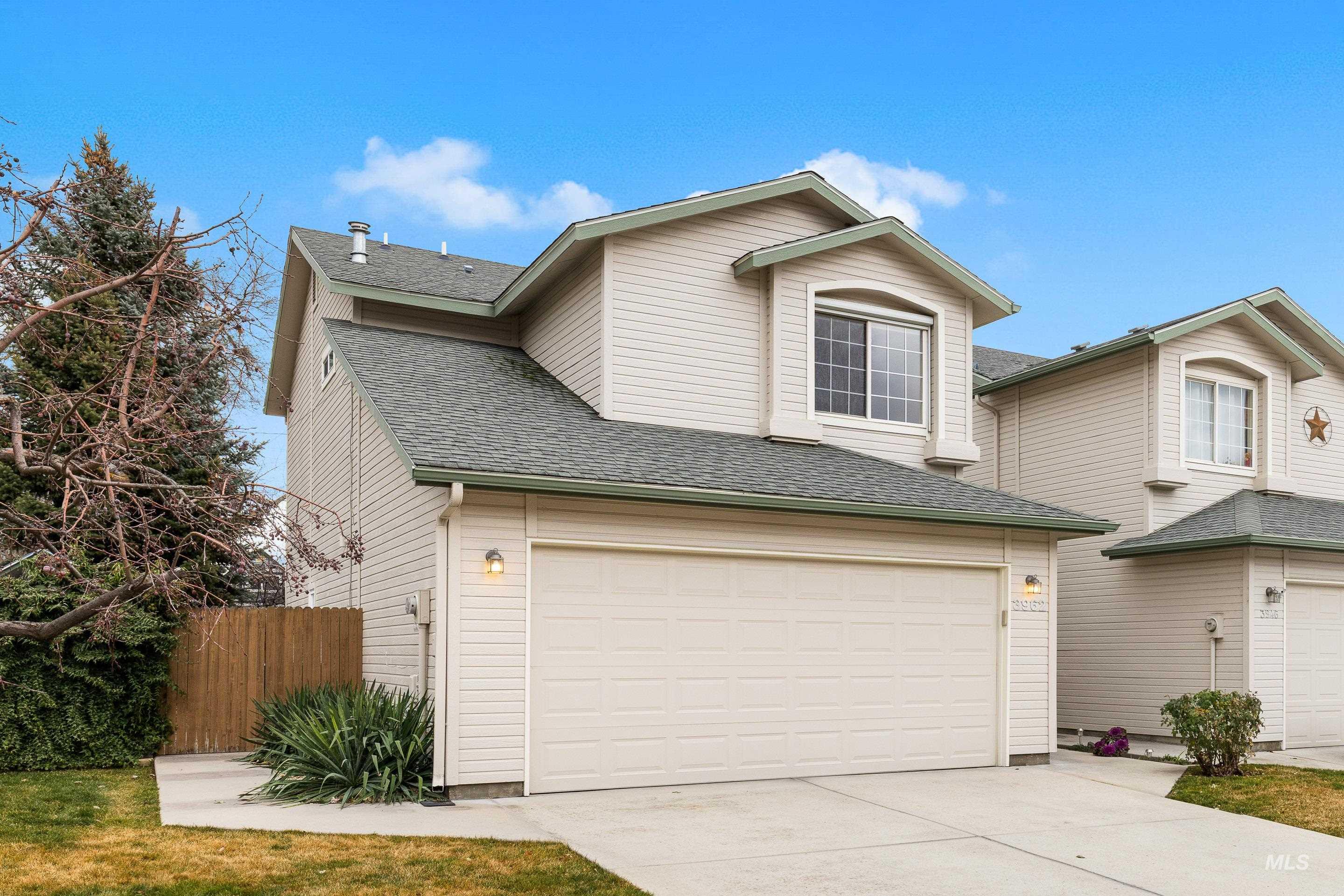 Traditional-style home featuring a shingled roof, driveway, and an attached garage