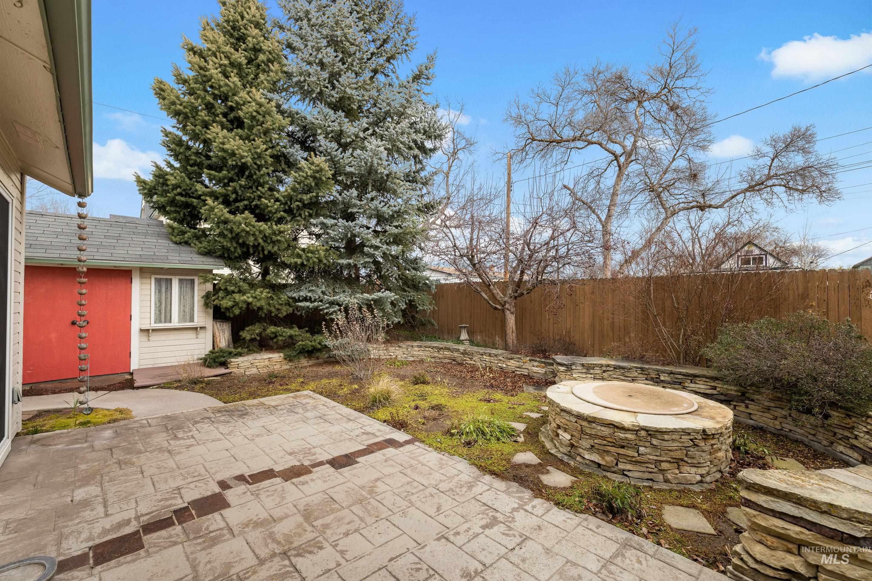 Fenced backyard featuring a patio and a fire pit