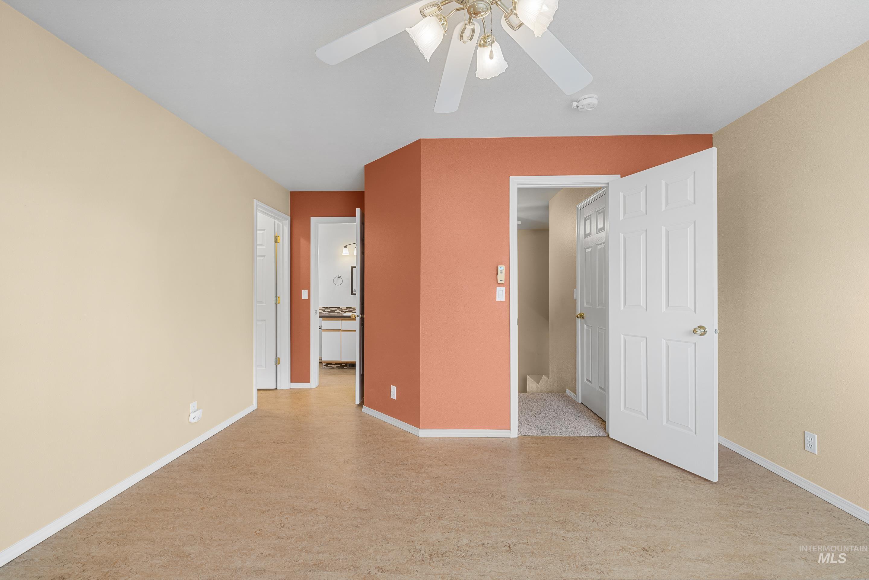 Unfurnished bedroom with ensuite bath and ceiling fan