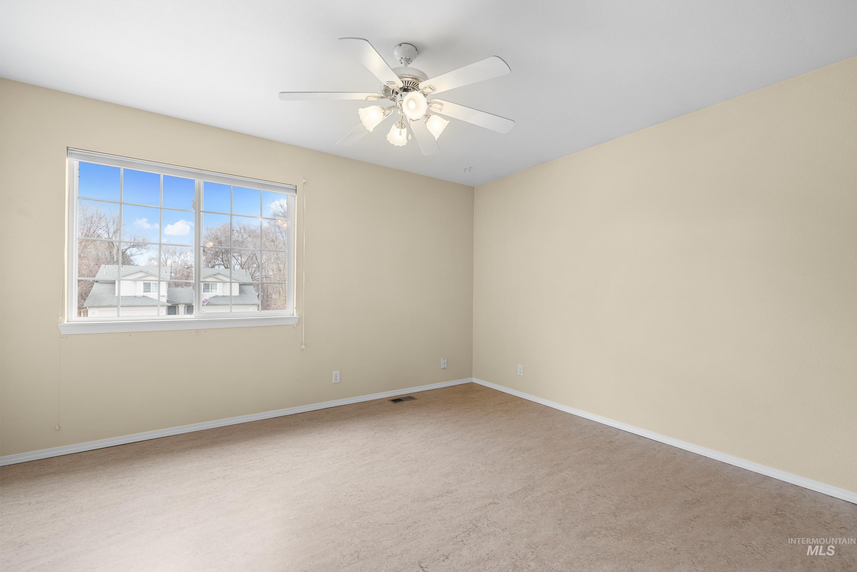 Spare room featuring ceiling fan and baseboards