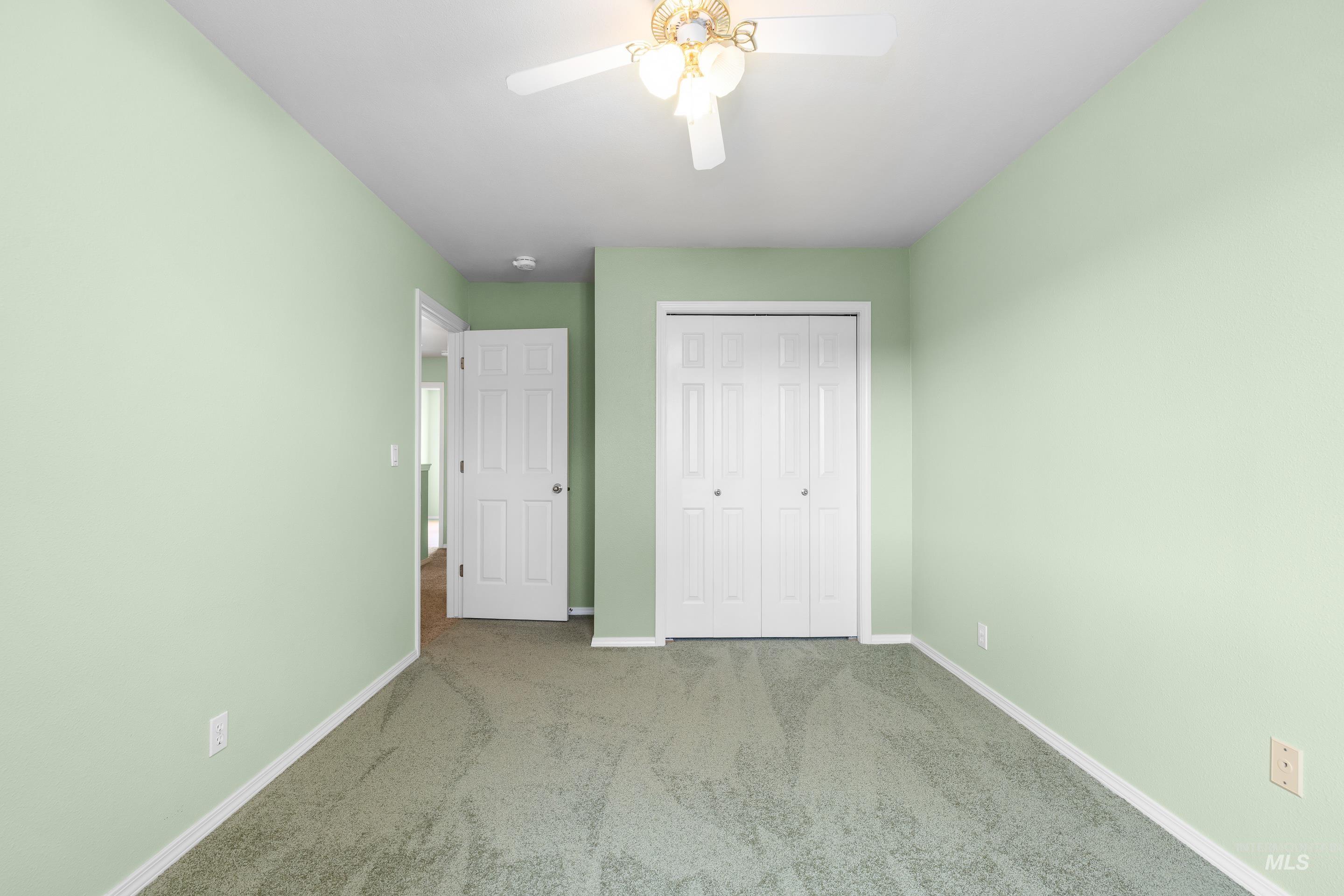 Unfurnished bedroom with carpet floors, a closet, and ceiling fan