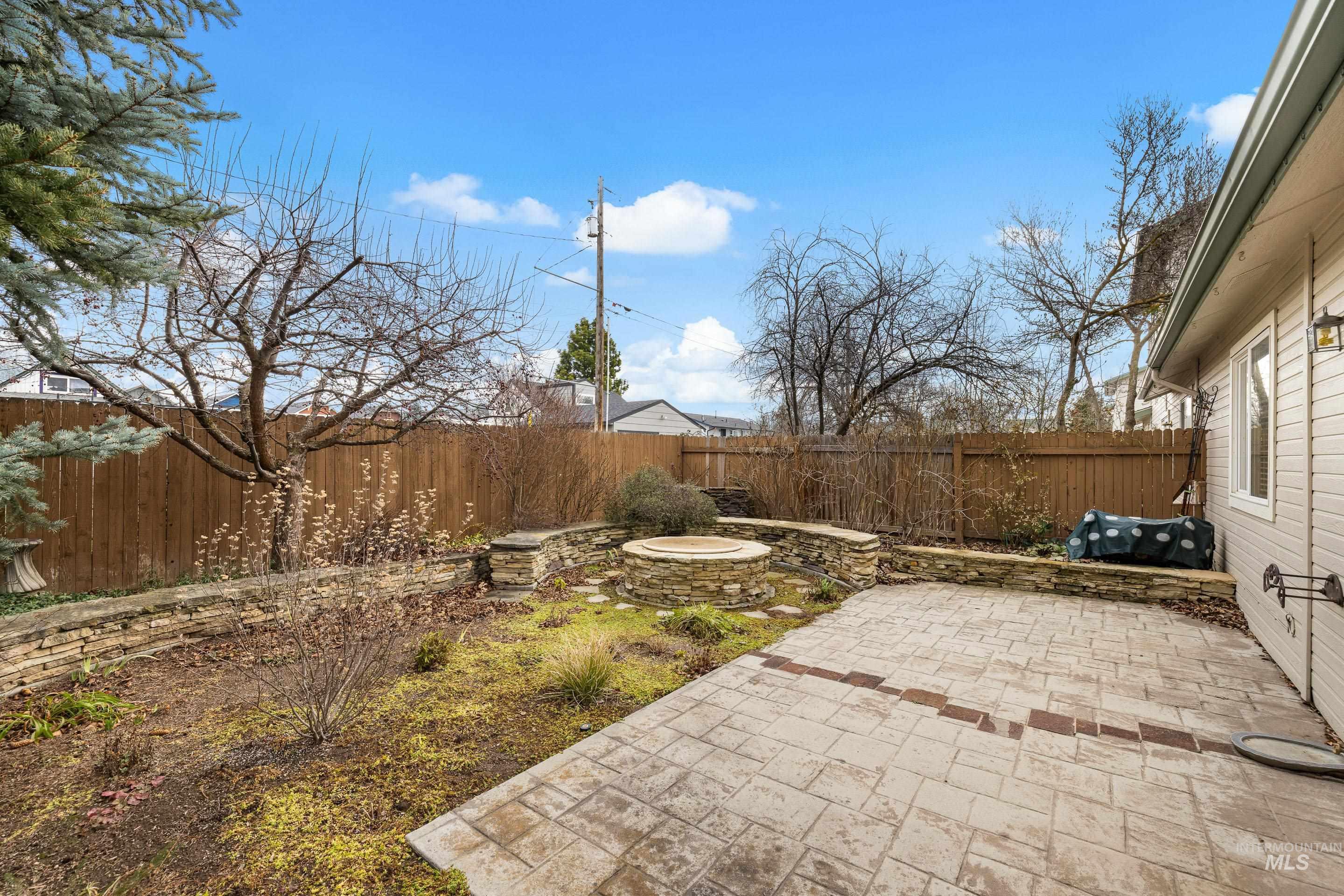 Fenced backyard featuring a patio area and a fire pit