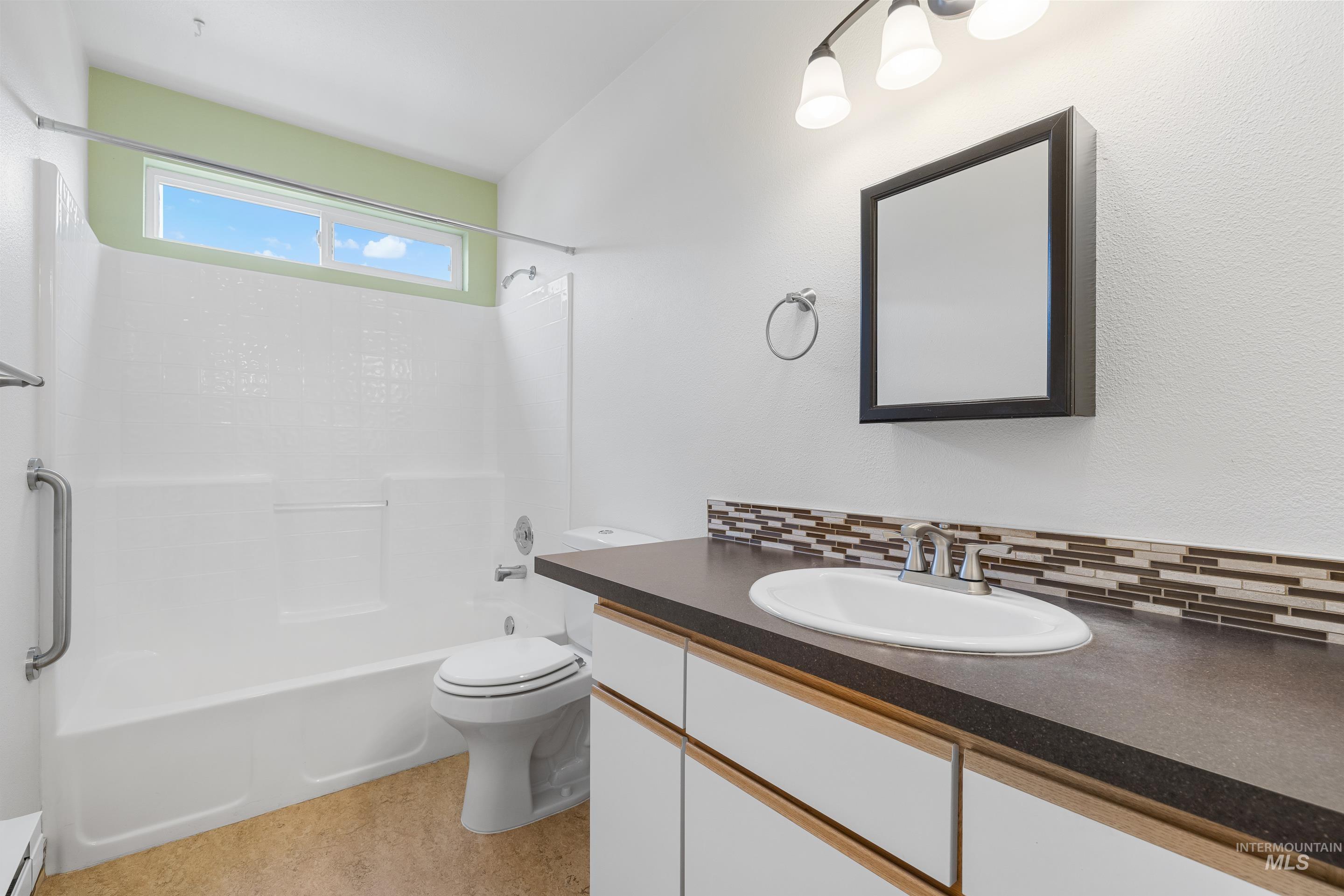 Bathroom with vanity, shower / tub combination, decorative backsplash, and a baseboard radiator
