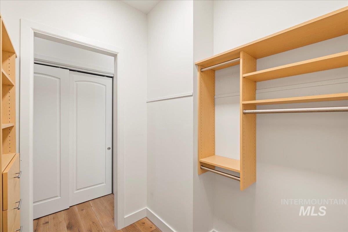 Walk in closet with light wood-style flooring