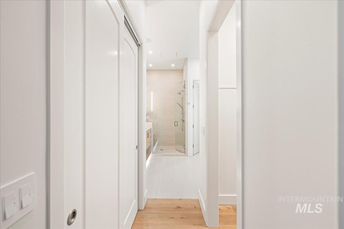 Hall with light wood-style floors and recessed lighting