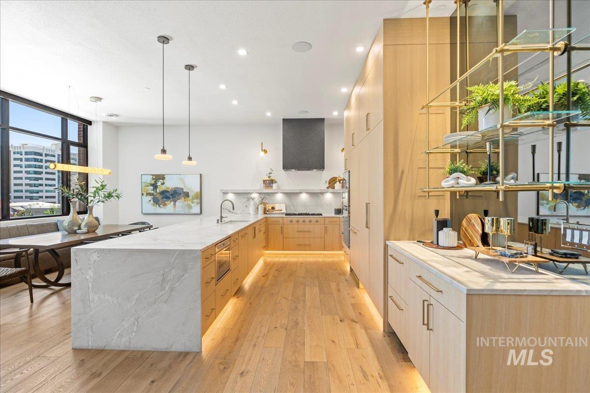 Kitchen featuring modern cabinets, light brown cabinets, light wood-style floors, light stone counters, and recessed lighting