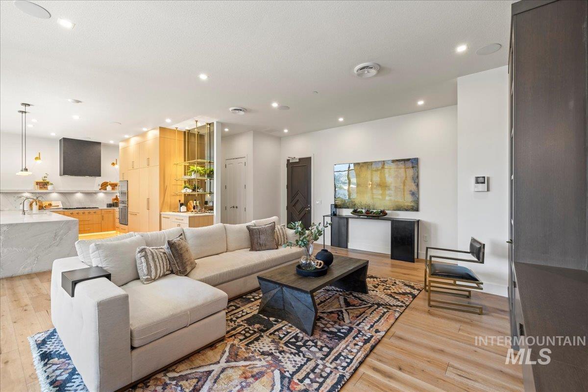 Living area featuring light wood-style floors and recessed lighting