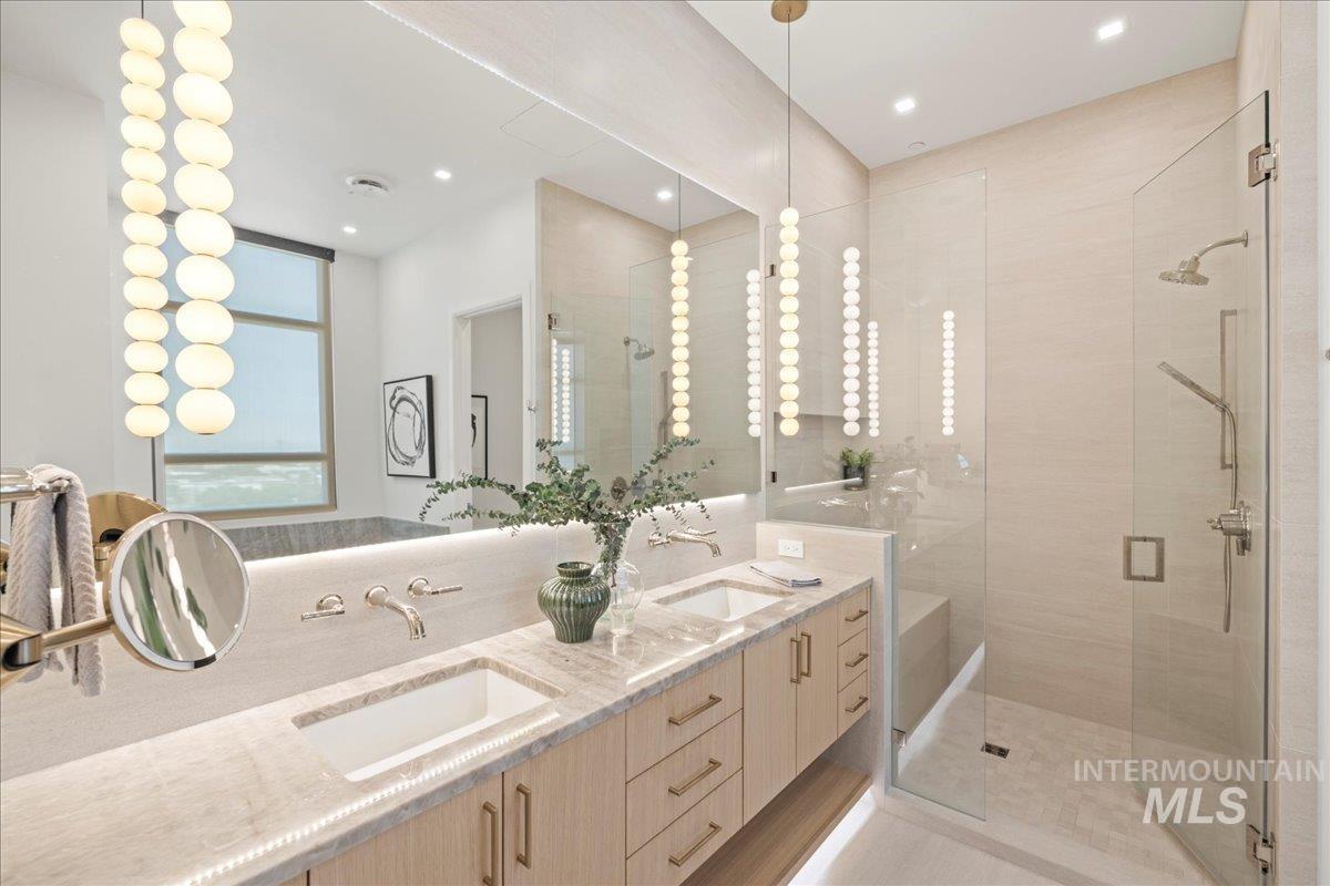 Full bathroom with a stall shower, double vanity, and recessed lighting