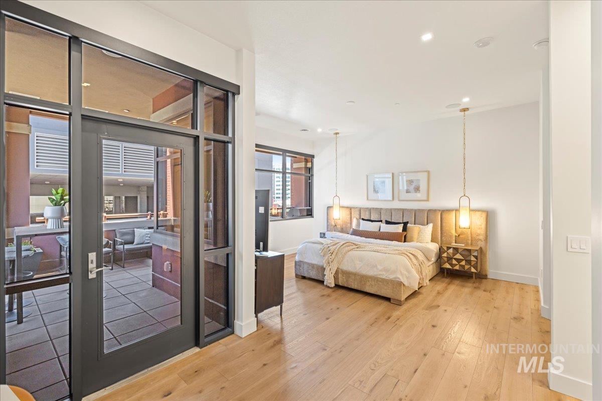 Bedroom featuring light wood-style flooring, recessed lighting, and access to exterior
