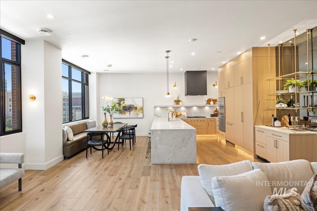 Living area with light wood-style flooring, recessed lighting, and a wall of windows