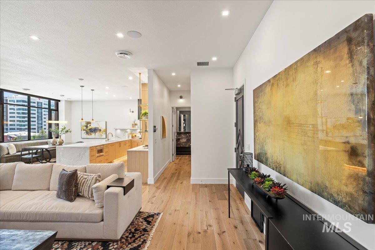 Living room with light wood-style flooring and recessed lighting