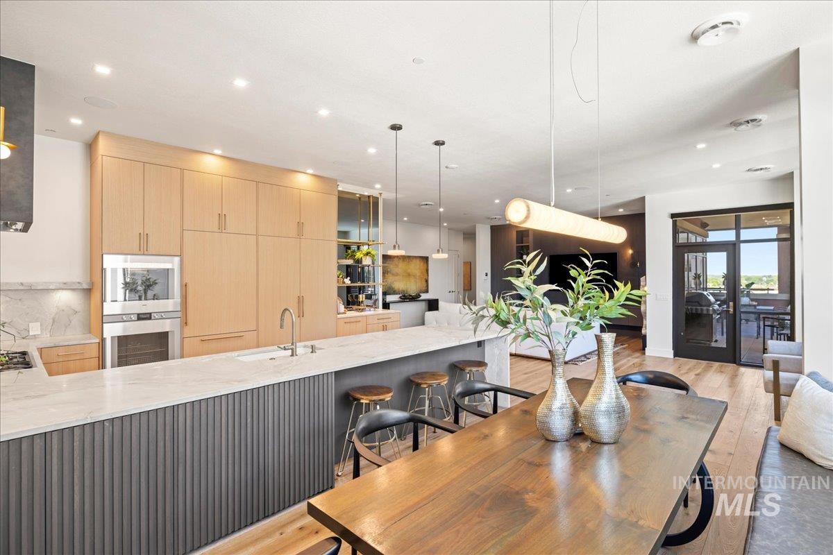 Dining area with recessed lighting, light wood finished floors, and french doors