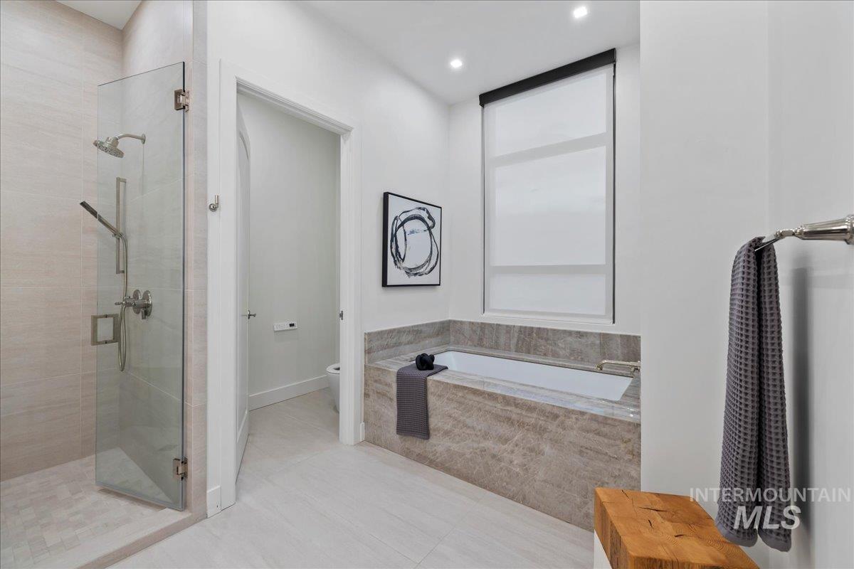Bathroom featuring a shower stall, a bath, tile patterned flooring, and recessed lighting