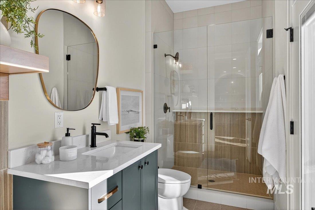Full bath featuring vanity, a stall shower, and tile patterned floors