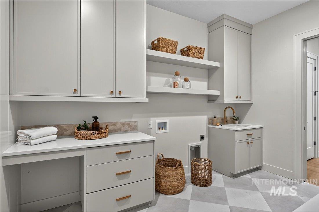 Laundry room featuring hookup for a washing machine, electric dryer hookup, light flooring, and cabinet space