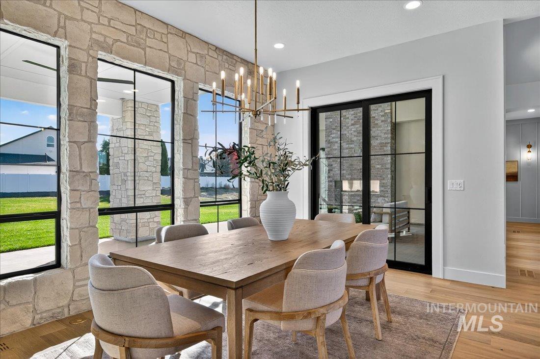 Dining room with light wood-style floors, a chandelier, and recessed lighting