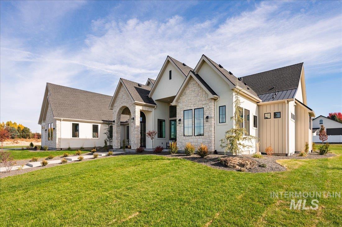 View of front of house featuring a front yard, board and batten siding, a standing seam roof, and a metal roof