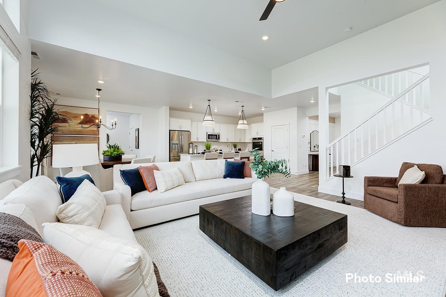 Living area featuring a chandelier, light wood-type flooring, recessed lighting, a ceiling fan, and stairs