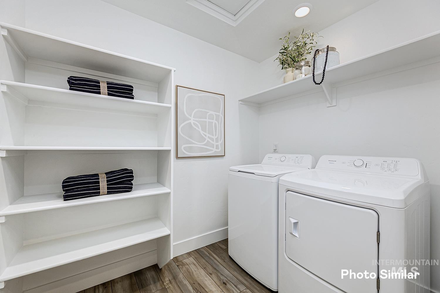 Laundry room with light wood-type flooring and washing machine and dryer