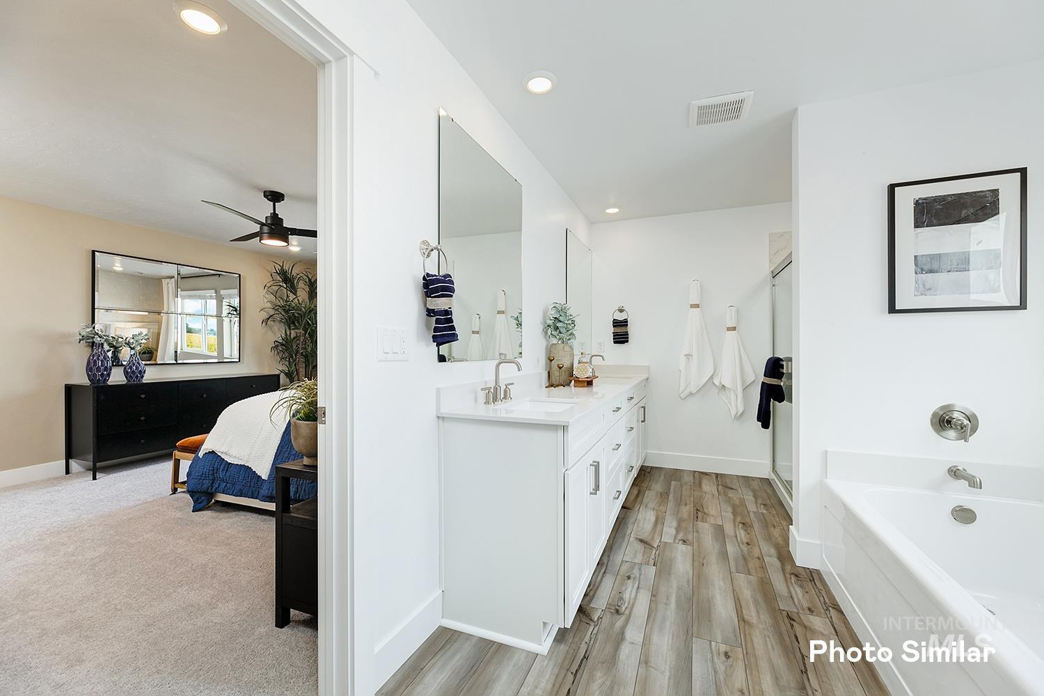 Bathroom with double vanity, recessed lighting, a garden tub, ensuite bathroom, and light wood-type flooring