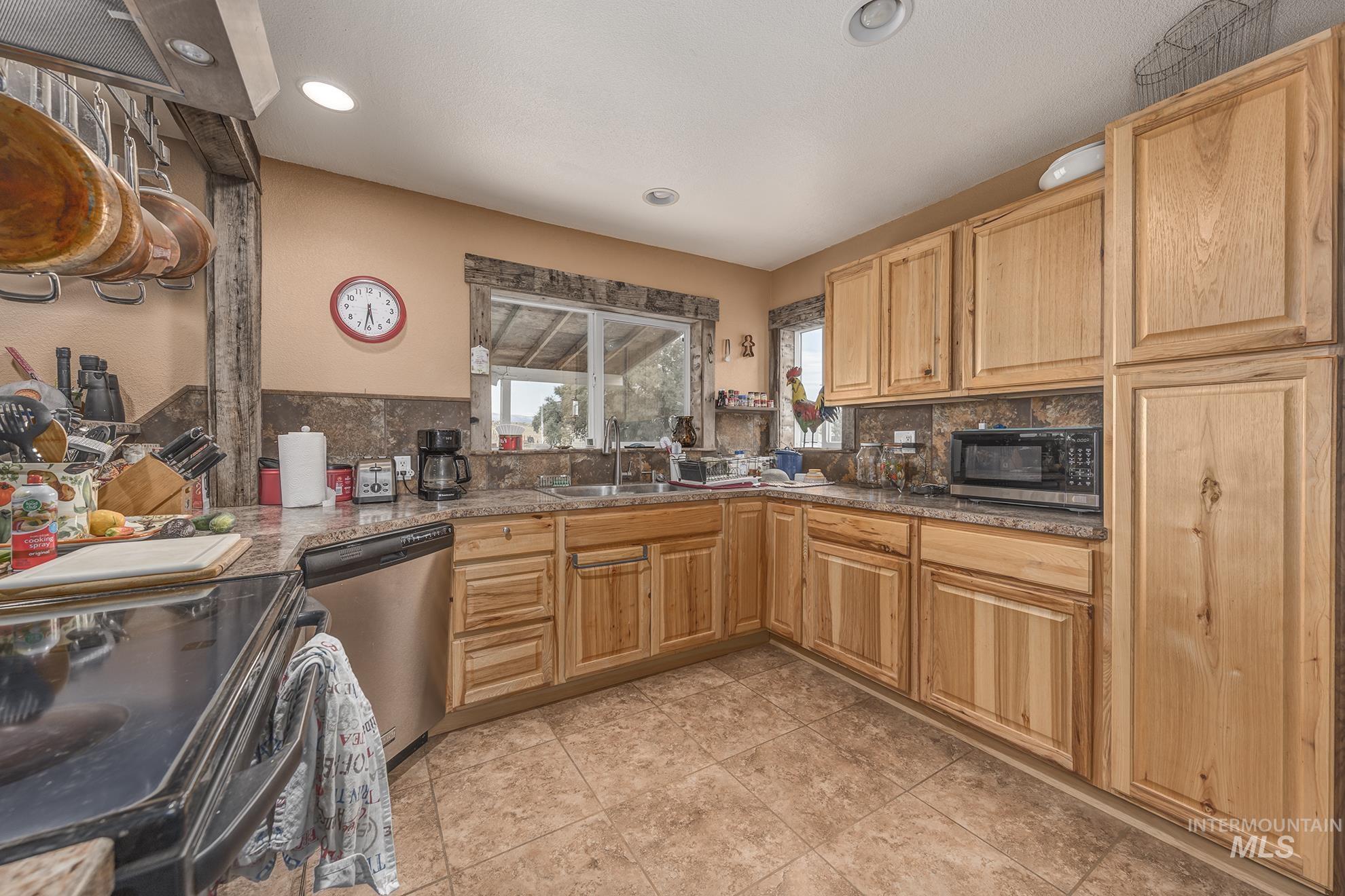 Kitchen featuring stove, decorative backsplash, dishwasher, recessed lighting, and light tile patterned floors