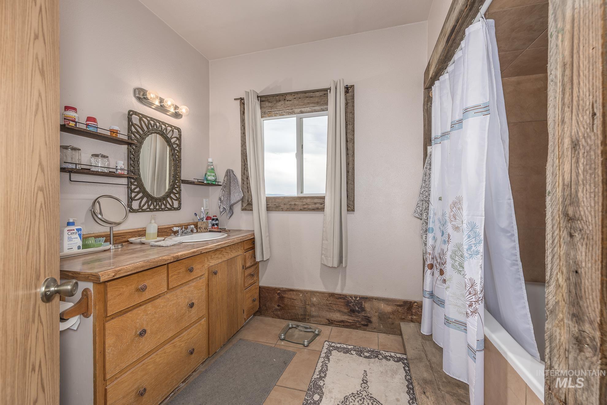 Full bath with vanity, shower / bath combination with curtain, and tile patterned floors