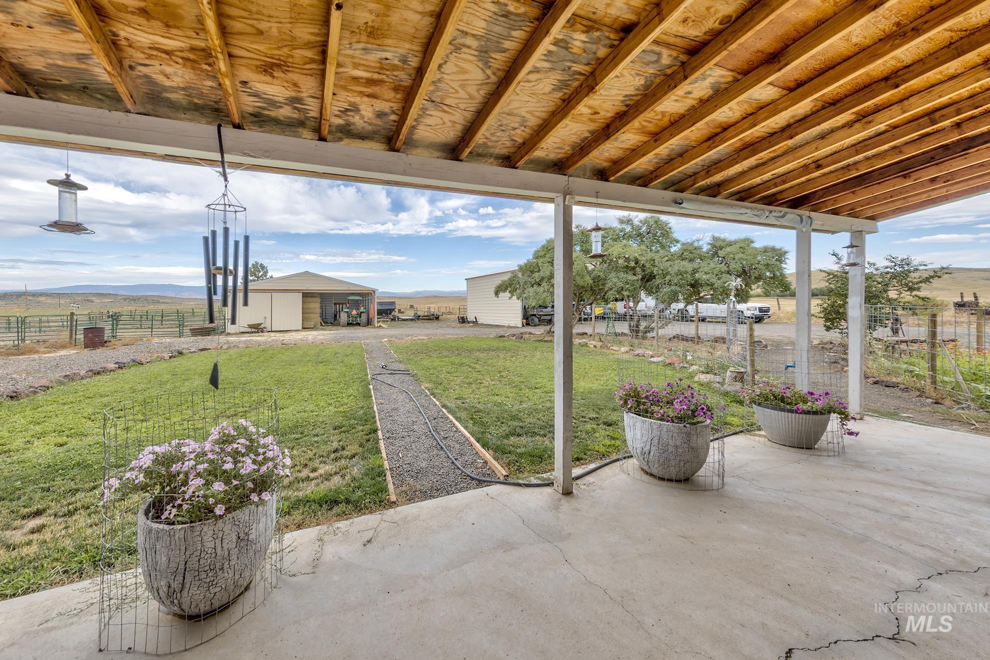 View of patio with a mountain view, an outdoor structure, and a view of rural / pastoral area