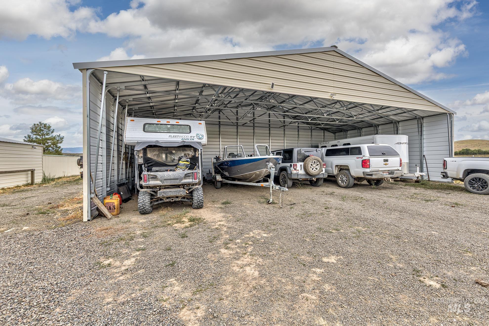 View of vehicle parking featuring a carport and dirt driveway